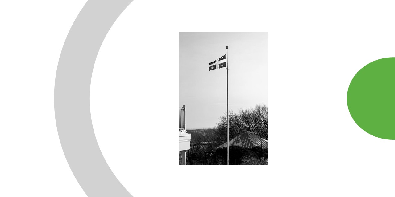 Drapeau du Québec (bleu et blanc) hissé tout haut vers le ciel.