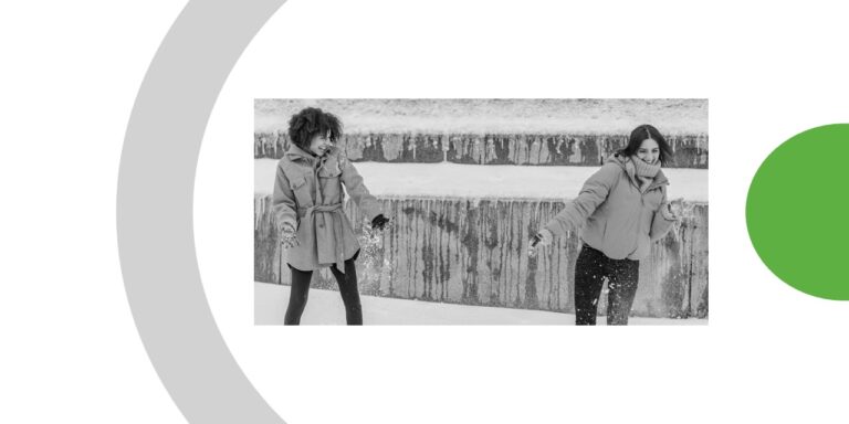 Deux jeunes filles debout en train de jouer sur la neige